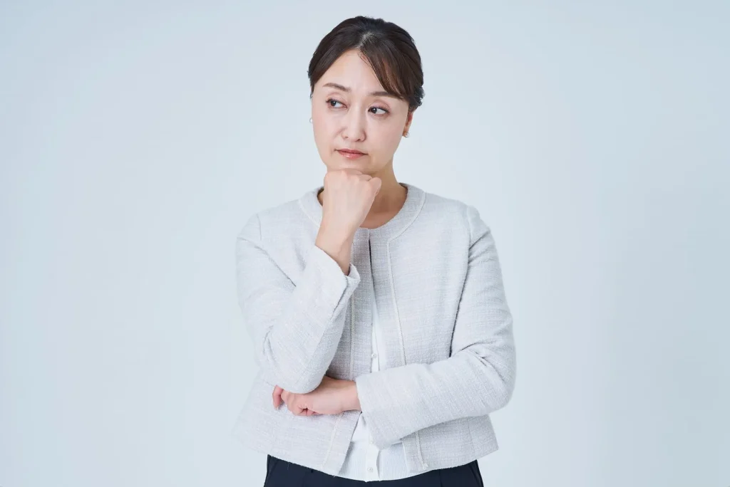 あごに手を添えて考え込む女性